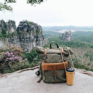 Urlaubsszene in den Bergen mit Rucksack und Trinkflasche