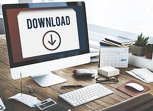 PC mit Tastatur. Auf dem Bildschirm ist ein Bild mit dem Wort "Download"